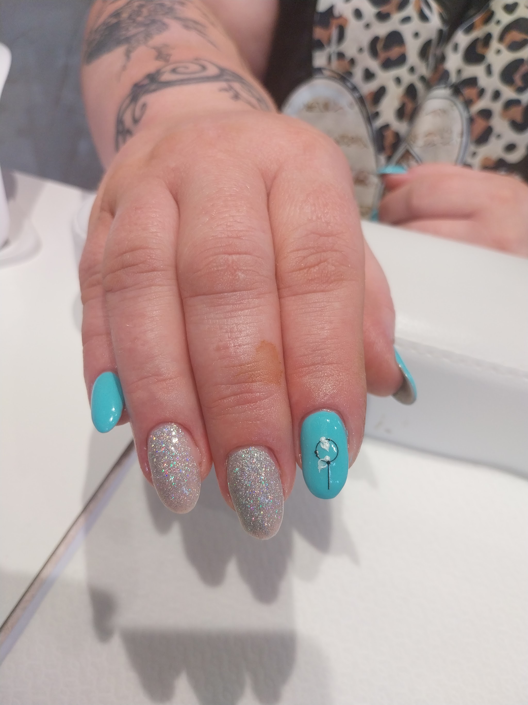 Turquoise en zilveren glittergelnagels met een steentje