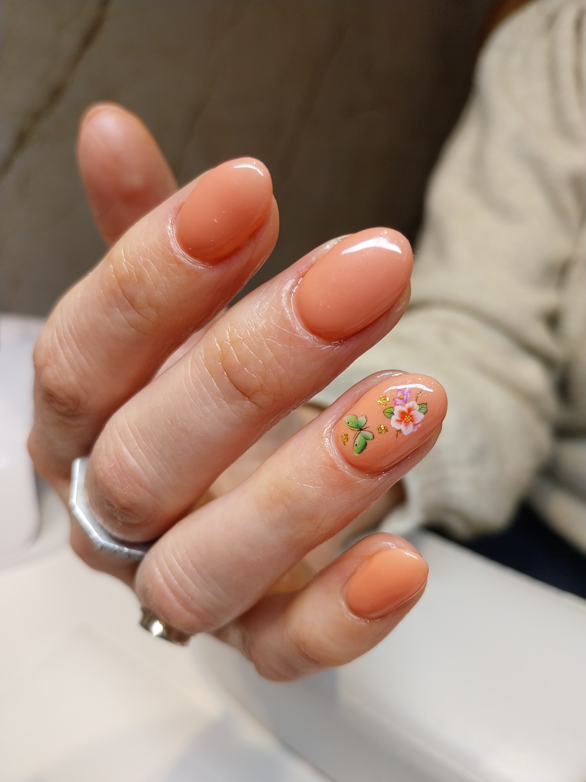 Perzikkleurige gelnagels met een handgeschilderd bloemetje