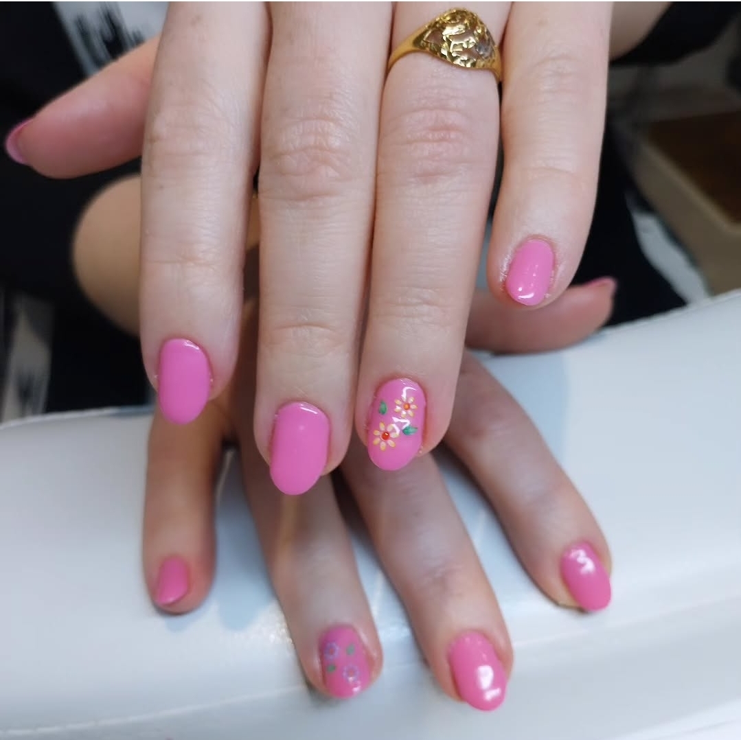 Roze gelnagels met bloemetjes en glitter als accent