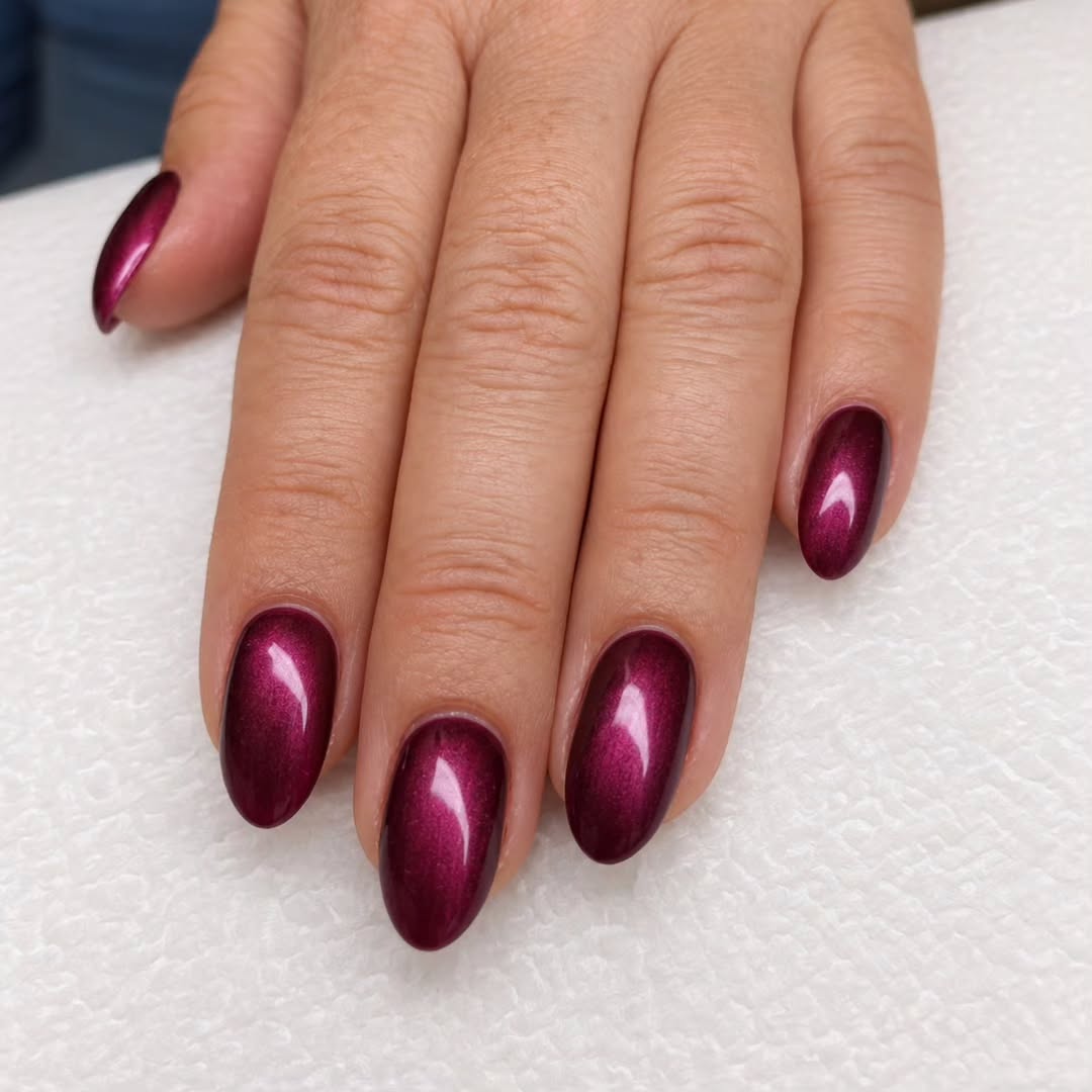 Glanzende bordeauxrode amandelnagels met cat-eye effect